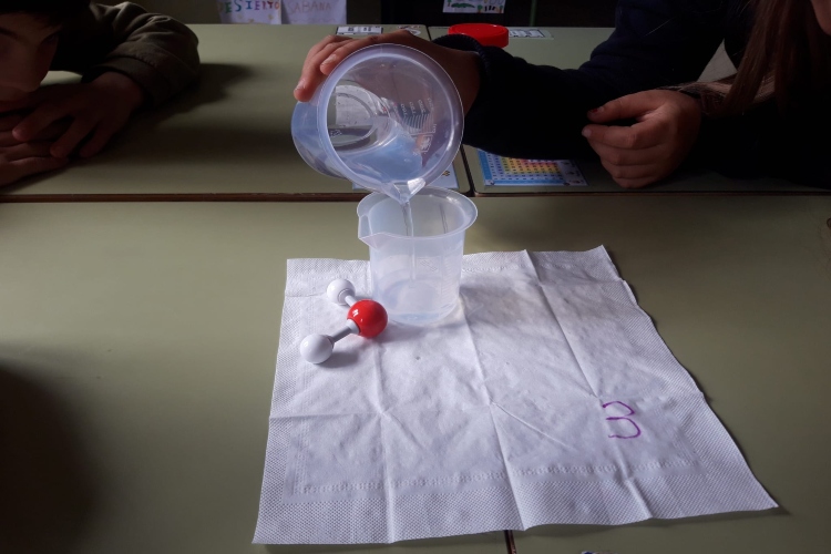 Unos niños realizan un experimento con agua durante la celebración de un taller educativo de Asturagua